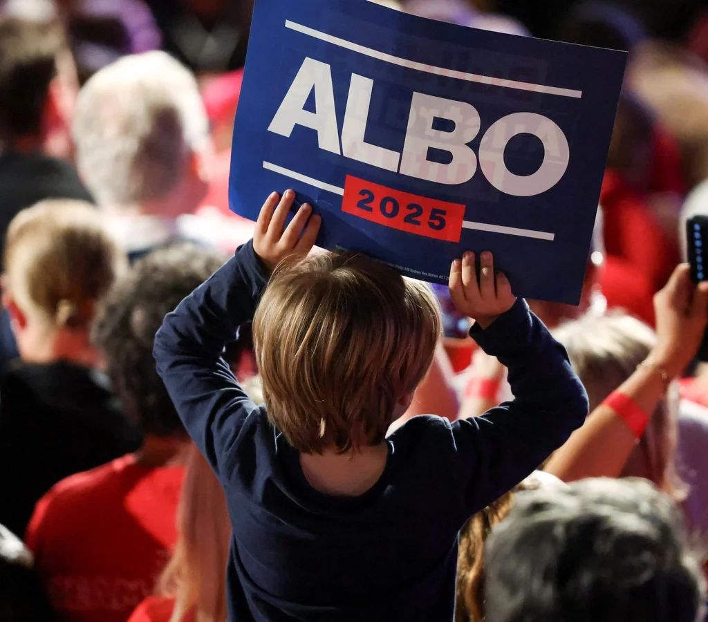 A child holds a placard at an Australian Labor Party election rally, symbolizing public support for progressive leadership in the 2025 elections.