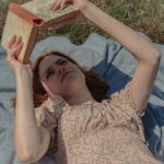 Person reading a book in natural light, symbolizing the mental and emotional power of reading