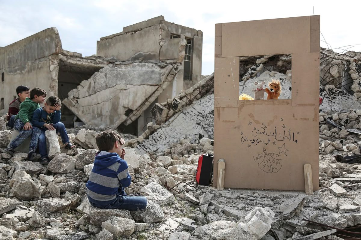 Ruins of a destroyed university building in Gaza, with debris and broken furniture symbolizing scholasticide.