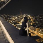 A thoughtful woman sitting alone in a dim room, lost in deep reflection