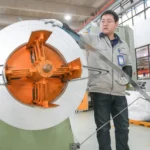 A worker in China manufactures battery components for electric vehicles, a growing segment of the global clean energy market.