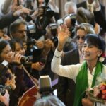 Protesters in Myanmar holding banners against military rule during the 2021 coup, symbolizing the ongoing struggle for democracy.